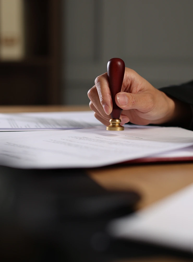 Hand pressing a wax seal stamp onto a legal document
