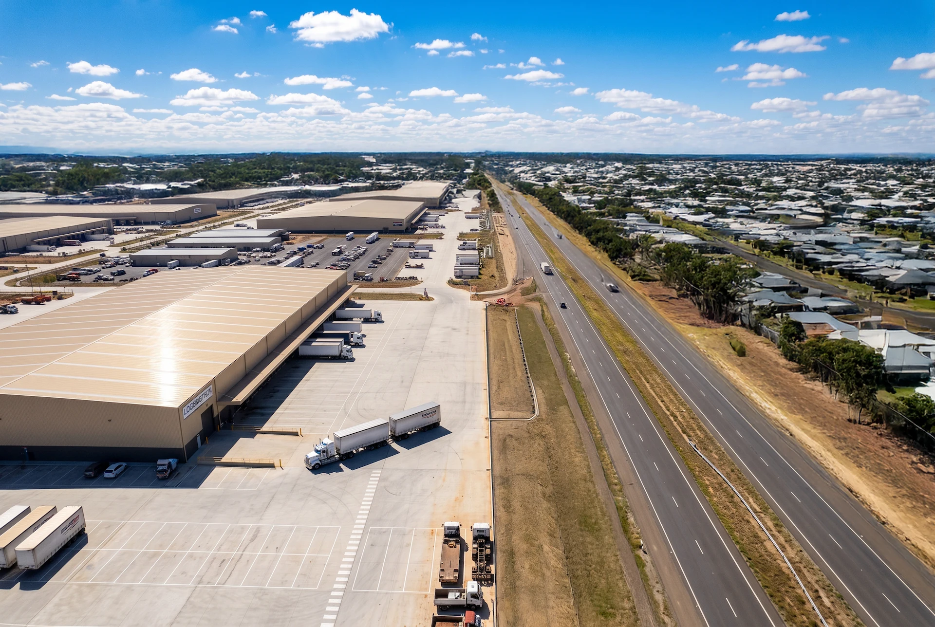 Aerial view of warehouses, trucks and a highway corridor