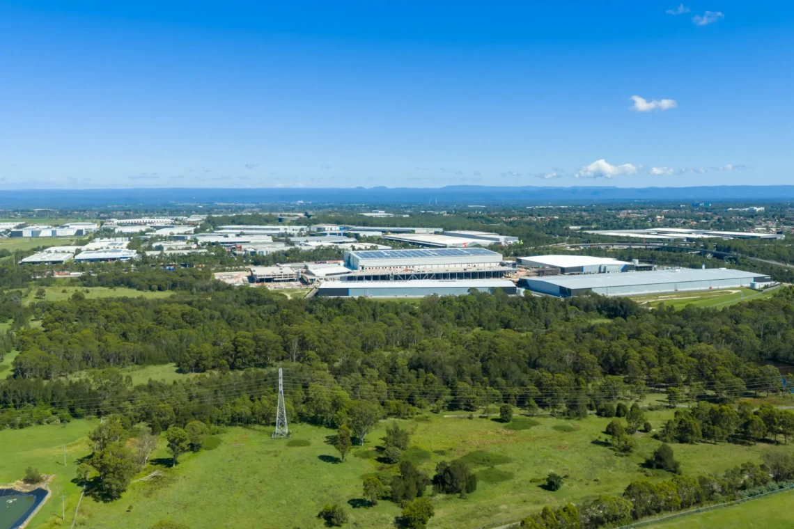 Aerial view of an industrial warehouse estate bordered by bushland