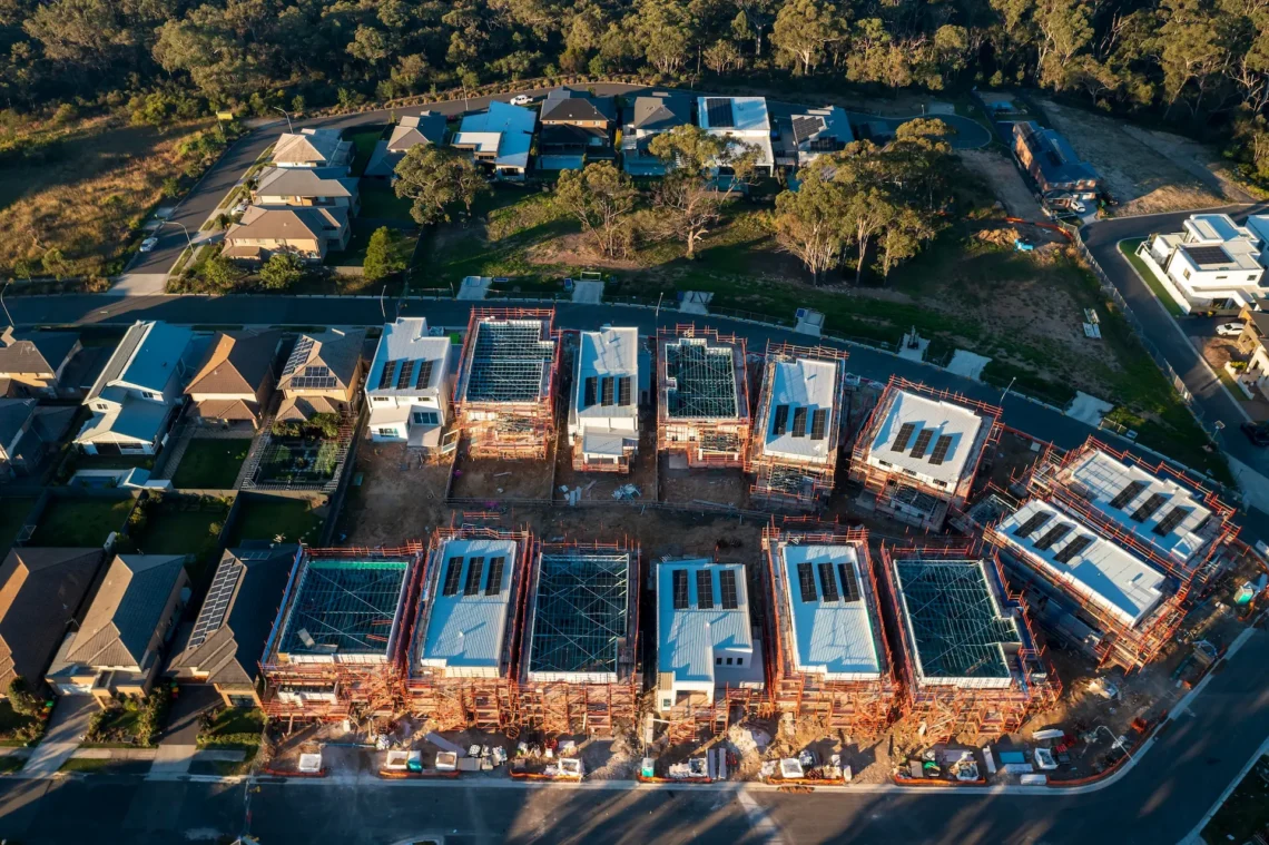 Aerial view of townhouses under construction beside established homes